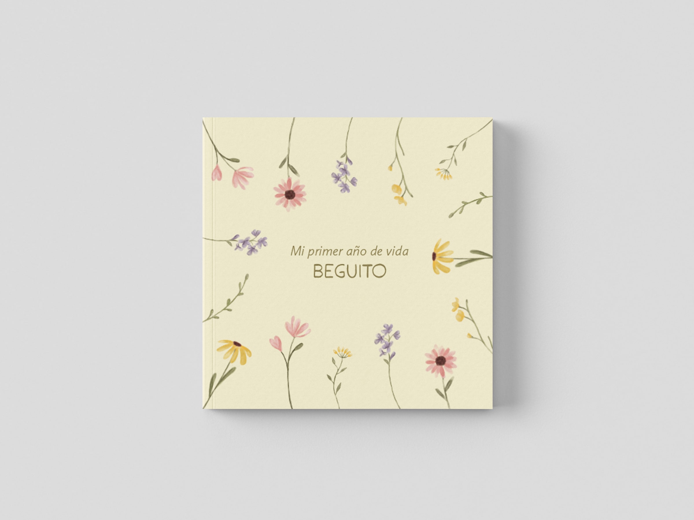 La tapa crema del fotolibro, con flores silvestres ilustradas alrededor del título «Mi primer año de vida» y el nombre de la niña.