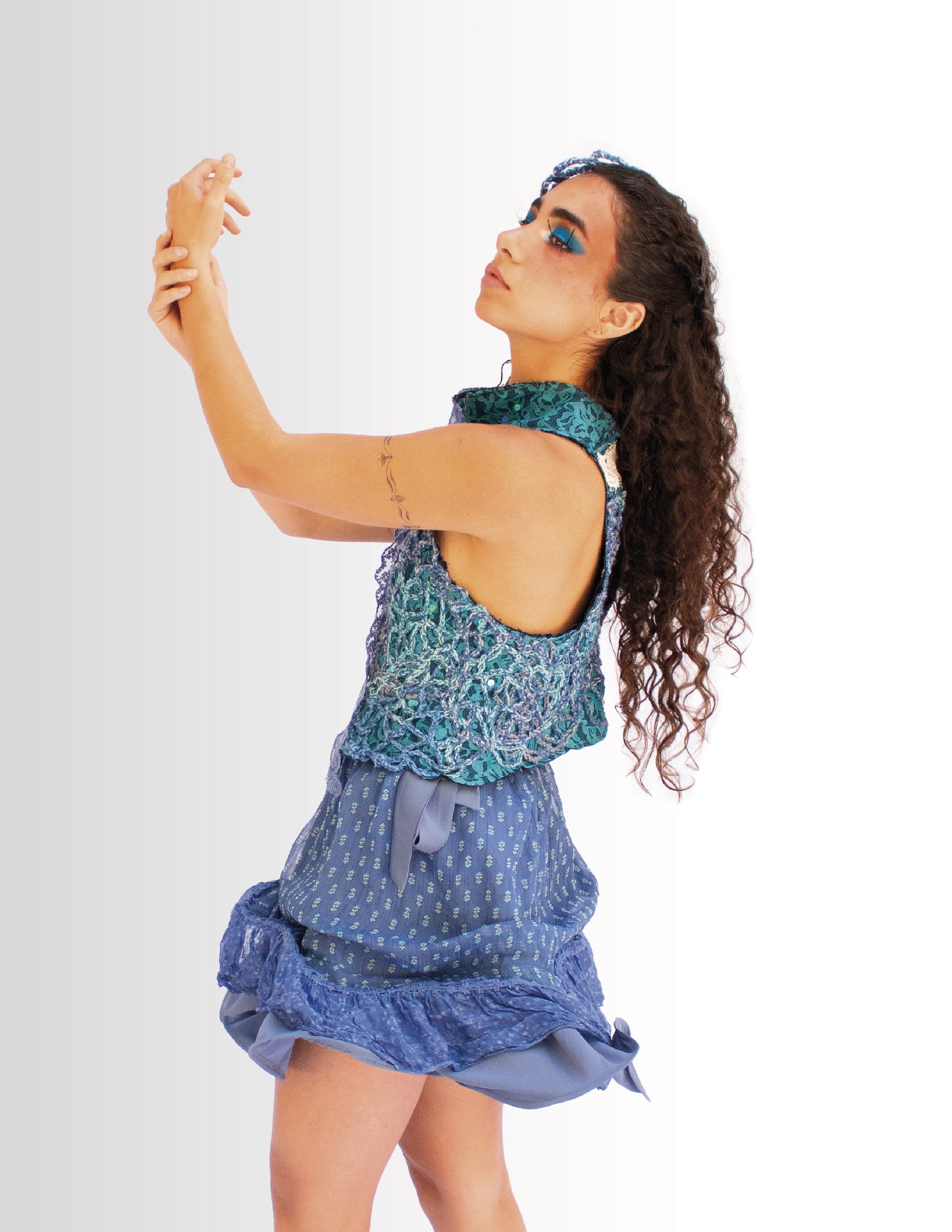 Modelo en movimiento con top de crochet turquesa y falda azul de vuelo.