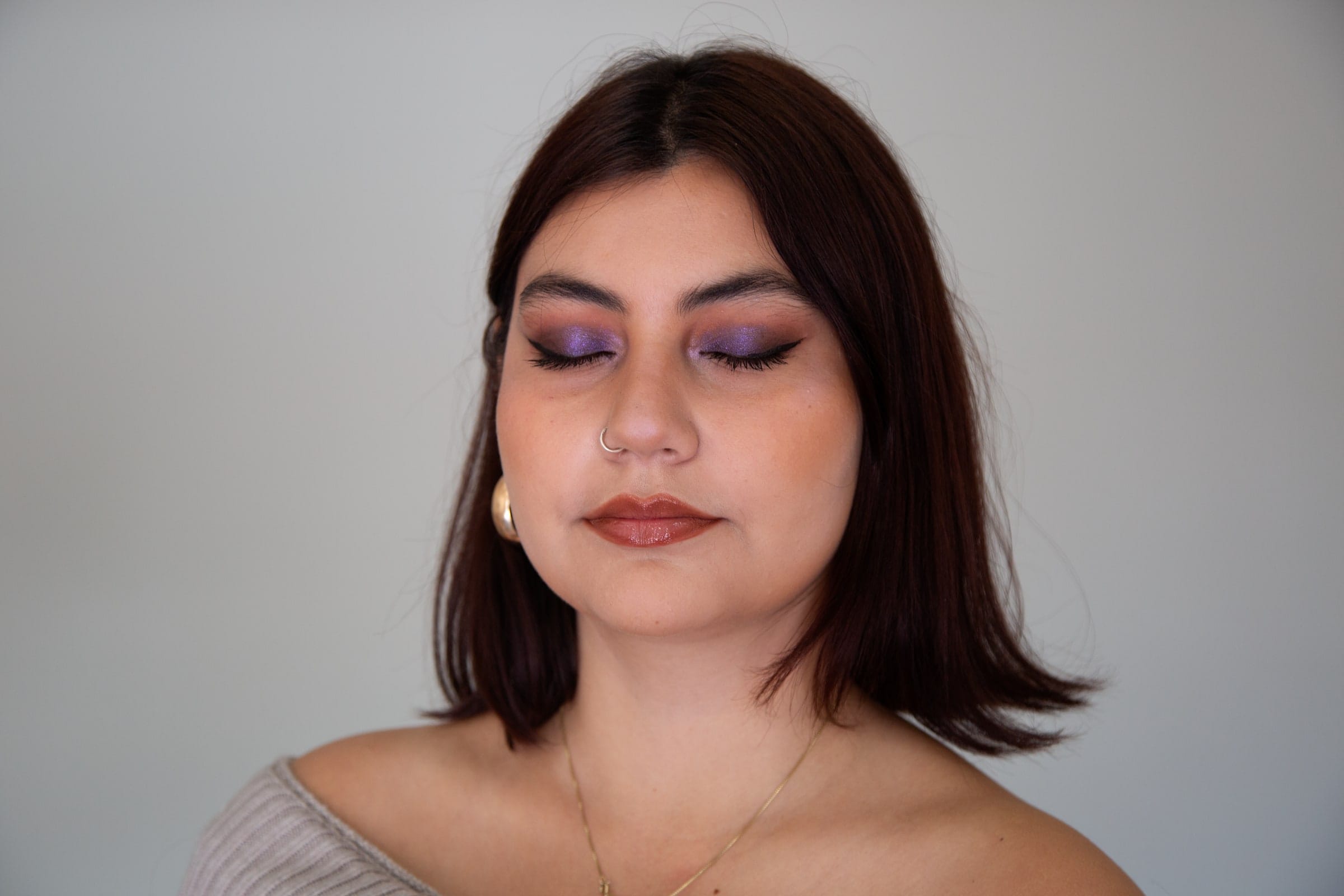 Retrato de maquillaje en encuadre apaisado, de frente y con los ojos cerrados.