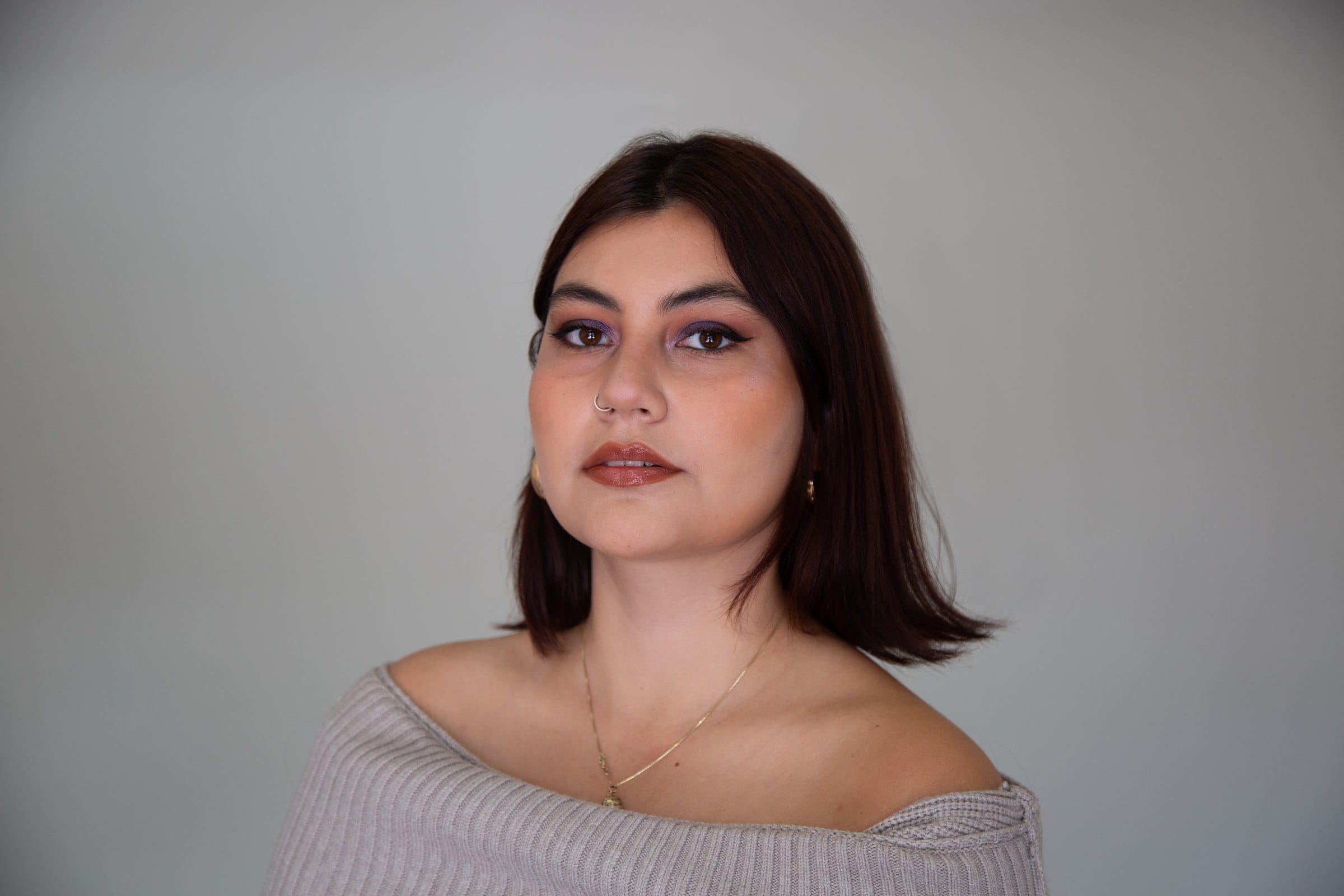 Retrato de maquillaje: la misma modelo mirando a la cámara sobre fondo gris.